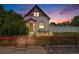 Charming home with red trim, decorative fence, landscaped yard and nice sunset at 3106 N Franklin St, Denver, CO 80205