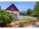 Charming home with red trim, a small front yard with a red metal fence and mature landscaping at 3106 N Franklin St, Denver, CO 80205