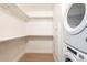 Organized walk-in closet with built-in shelving and a convenient stacked washer and dryer at 1901 Wazee St # 305, Denver, CO 80202