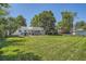 Expansive backyard featuring a large lawn, mature trees, and covered patio seating area at 366 Kenton St, Aurora, CO 80010