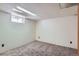Spacious basement area with gray carpet, white paneled walls, and a small window for natural light at 366 Kenton St, Aurora, CO 80010