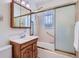 A bathroom featuring a shower/tub, vanity with storage, and glass shower doors at 366 Kenton St, Aurora, CO 80010