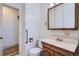 A bathroom with grab bars, and vanity sink with a wood frame mirror at 366 Kenton St, Aurora, CO 80010