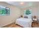 Cozy bedroom featuring wood floors, two windows, and a comfortable queen-sized bed at 366 Kenton St, Aurora, CO 80010