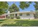 Charming white brick home with a well-maintained lawn, mature trees, and a cozy front porch at 366 Kenton St, Aurora, CO 80010