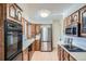 Open kitchen with oak cabinets, stainless steel appliances, and modern lighting at 366 Kenton St, Aurora, CO 80010