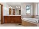 Main bathroom with double vanity, soaking tub and window at 486 S Youngfield Cir, Lakewood, CO 80228