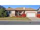 Ranch style home with attached two-car garage and manicured lawn at 486 S Youngfield Cir, Lakewood, CO 80228