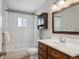 Clean bathroom features a shower-tub combo, wood vanity, and a classic subway tile surround at 1760 S Yuma St, Denver, CO 80223