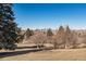 Distant city skyline view from a grassy area with trees, showcasing the community's location at 1760 S Yuma St, Denver, CO 80223