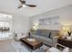 Bright living room featuring a ceiling fan, gray sofa with blue pillows, and stylish decor at 1760 S Yuma St, Denver, CO 80223