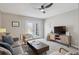 Bright living room with neutral decor, a ceiling fan and doors to the backyard at 1760 S Yuma St, Denver, CO 80223