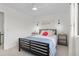 A clean bedroom with large window, ceiling fan, side tables, decorative sconces and neutral carpeting at 8674 Carr Loop, Arvada, CO 80005