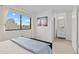 Bedroom with large window, neutral decor and open view to an ensuite bathroom at 8674 Carr Loop, Arvada, CO 80005