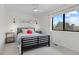 A bright bedroom with large window, ceiling fan, side tables, decorative sconces and updated window treatments at 8674 Carr Loop, Arvada, CO 80005