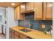 Modern kitchen featuring butcher block countertops, stylish backsplash, and stainless steel fixtures at 8674 Carr Loop, Arvada, CO 80005