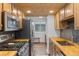 Well-equipped kitchen with stainless steel appliances, butcher block countertops, backsplash, and wood ceiling at 8674 Carr Loop, Arvada, CO 80005