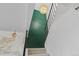 View looking upward through a stairwell with black metal railing, painted green accent wall and modern light fixture at 8674 Carr Loop, Arvada, CO 80005