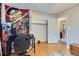 Bedroom featuring wood floors, open closet space and adjacent bathroom access at 1325 Elder St, Denver, CO 80221