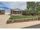 Charming brick home featuring a well-maintained lawn and a detached garage at 1325 Elder St, Denver, CO 80221