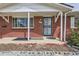 Close-up of front porch with brick facade and black security door and concrete blocks at 1325 Elder St, Denver, CO 80221