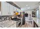 Updated kitchen with granite countertops, stainless steel appliances, and white cabinets at 1325 Elder St, Denver, CO 80221