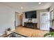 Hardwood floors in a living room with a fireplace, TV, and front entry at 1325 Elder St, Denver, CO 80221