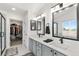 Bright bathroom featuring dual vanity, quartz counters, large mirrors, and modern fixtures at 11853 Trail View Ln, Parker, CO 80134