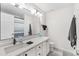 Bathroom featuring quartz counters, white cabinets, and a large mirror at 11853 Trail View Ln, Parker, CO 80134
