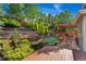 Lush backyard features mature trees, terraced brick walls, pond, and a cozy deck with pergola at 11932 W 56Th Cir, Arvada, CO 80002