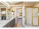 Bathroom vanity with a shower room and a view into the main bedroom at 11932 W 56Th Cir, Arvada, CO 80002