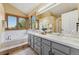 Well-lit bathroom with double vanity, large tub, and bright windows at 11932 W 56Th Cir, Arvada, CO 80002
