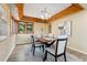Elegant dining area featuring modern lighting, hardwood floors, and views of the landscaped yard at 11932 W 56Th Cir, Arvada, CO 80002