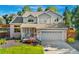 Charming two-story home featuring a covered porch, lush landscaping, and an attached two-car garage at 11932 W 56Th Cir, Arvada, CO 80002