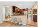 Bright kitchen with granite counters, stainless appliances, dark wood cabinetry, and breakfast bar at 11932 W 56Th Cir, Arvada, CO 80002