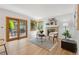 Cozy living room with brick fireplace, wood-framed glass doors, and hardwood floors at 11932 W 56Th Cir, Arvada, CO 80002