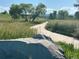 Scenic park path winding through tall grass, framed by a large rock in the foreground at 11932 W 56Th Cir, Arvada, CO 80002