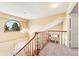 Upstairs landing with wood railing, carpeted floors and a distinctive arched window feature at 11932 W 56Th Cir, Arvada, CO 80002