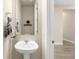 Half bathroom featuring a pedestal sink with modern fixtures, a mirror, and neutral wall decor with a plant at 15640 Spruce St, Thornton, CO 80602