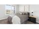 Bright bedroom features neutral tones, a comfortable bed with decorative pillows, and natural light from a large window at 15640 Spruce St, Thornton, CO 80602