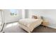 Minimalist bedroom featuring a bed with a tufted headboard, a nightstand, and a large window with natural light at 15640 Spruce St, Thornton, CO 80602