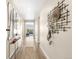 Bright hallway with decorative mirrors, a console table, and stylish wall art, leading to the living area at 15640 Spruce St, Thornton, CO 80602