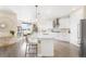 Bright, open kitchen with stainless steel appliances and an eat-in island, seamless to dining area at 15640 Spruce St, Thornton, CO 80602