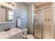 Bright bathroom with a shower, and neutral tile walls; vanity features a sink and bronze fixtures at 7244 W Portland Ave, Littleton, CO 80128