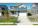 Two-story home with a gray exterior, white garage door, and landscaped lawn at 27480 E Cedar Pl, Aurora, CO 80018