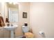 Classic half-bathroom featuring a pedestal sink, toilet, and framed artwork at 7352 E 7Th Ave # 7, Denver, CO 80230