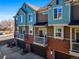Attractive multi-level townhomes featuring colorful siding, brick accents, private balconies, and attached garages at 7352 E 7Th Ave # 7, Denver, CO 80230