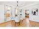 Dining room with a glass table, four light colored chairs, and hardwood floors and a view into the kitchen at 3419 Stuart St, Denver, CO 80212