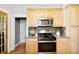 Kitchen with wooden cabinets, stainless steel appliances, granite countertops, and hardwood floors at 3419 Stuart St, Denver, CO 80212