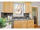 Kitchen sink with wood cabinets, granite countertops, and a window view to the outside and hardwood floors at 3419 Stuart St, Denver, CO 80212